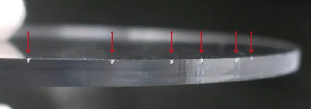 Närbild på plexiglas med markerade skärmärken.